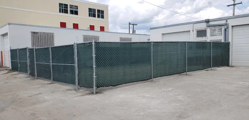 Chain link fence with green privacy slats at commercial property