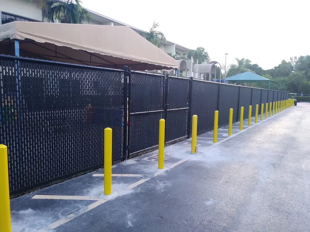 Black privacy slat chain link fence at commercial parking lot
