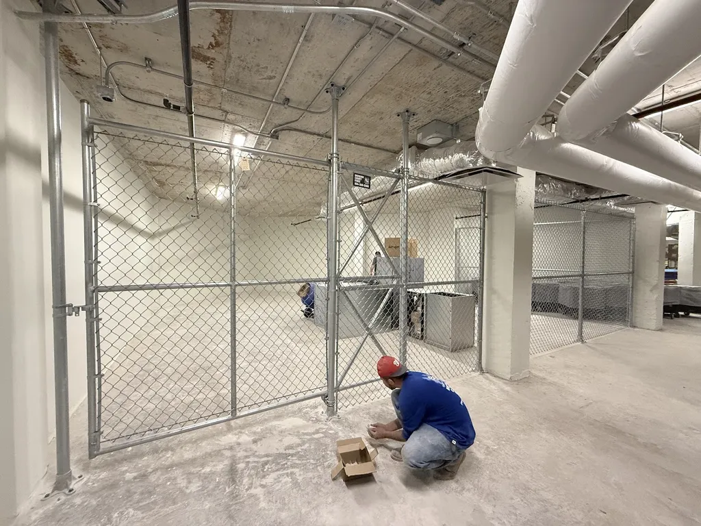 Chain link fence installation contractor working on commercial indoor security fencing