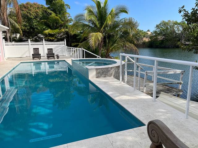 White aluminum railing around a waterfront pool deck