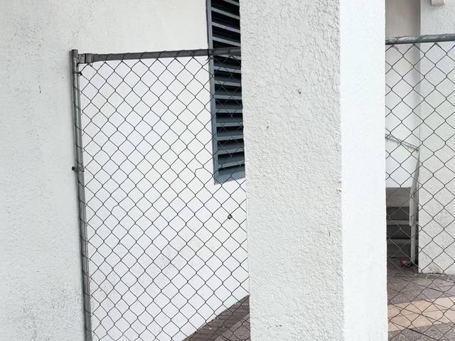 Chain link fence panel beside a white building