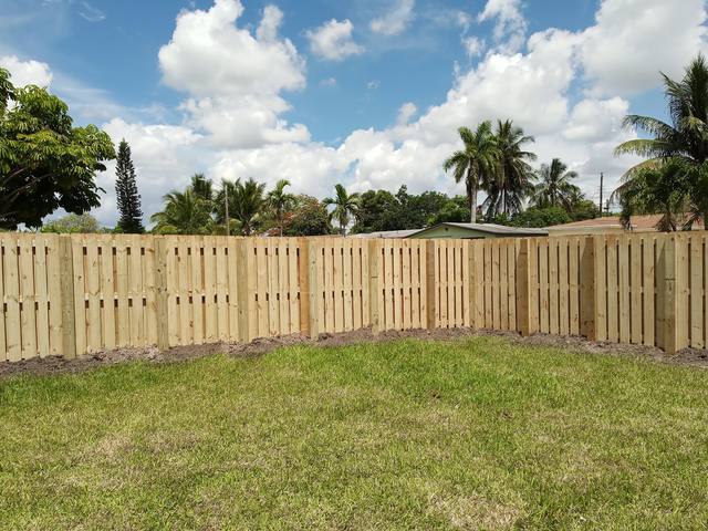 New wood shadowbox fence around a lawn